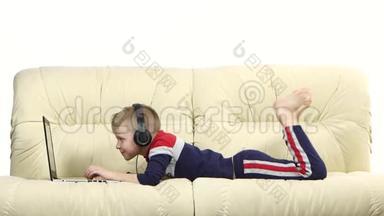 戴着耳机在沙发上<strong>玩电脑</strong>游戏的青少年